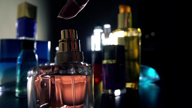 女人在黑暗中喷香水。慢动作特写镜头视频下载