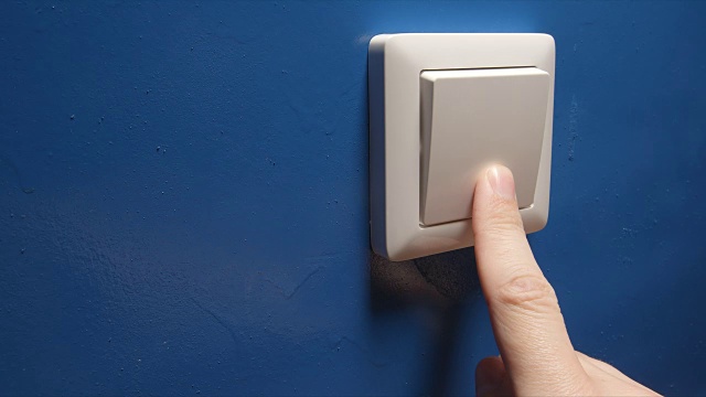 人的手关闭电源按钮在一个蓝色的墙侧视图视频下载