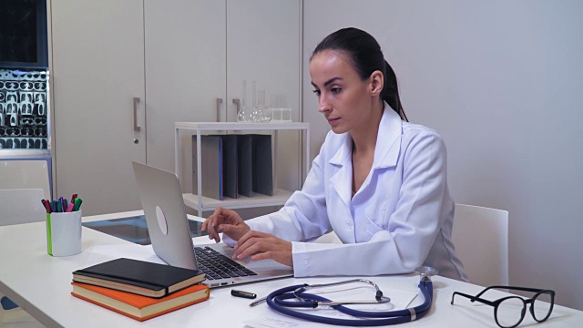 女性医学博士在诊所用笔记本上网视频下载