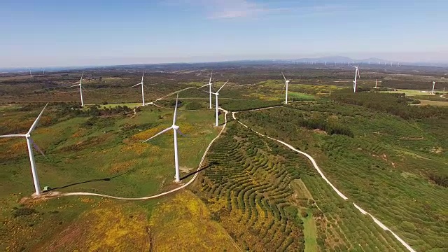 鸟瞰图的风力发电站在绿色的田野上的背景蓝色的天空。葡萄牙。视频素材