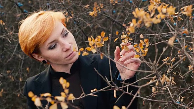 红头发的女孩在镜头前摆姿势，秋天的季节视频素材