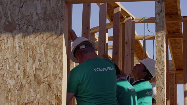 志愿者在建筑工程上筑墙视频素材