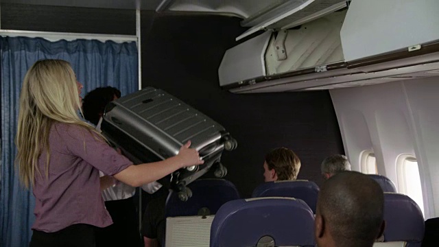 空乘人员帮助乘客搬运行李视频素材