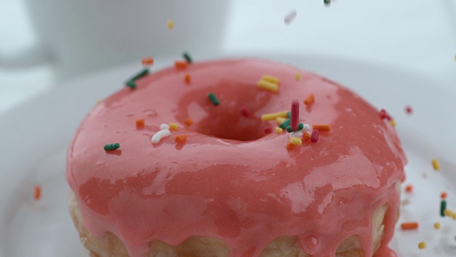 糖屑慢动作落在甜甜圈上视频素材