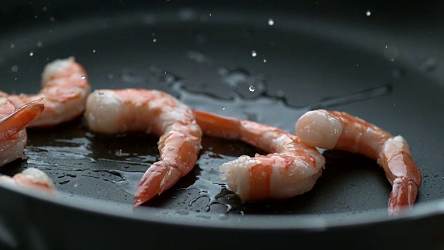 虾仁在煎锅中溅入热油，慢动作视频素材