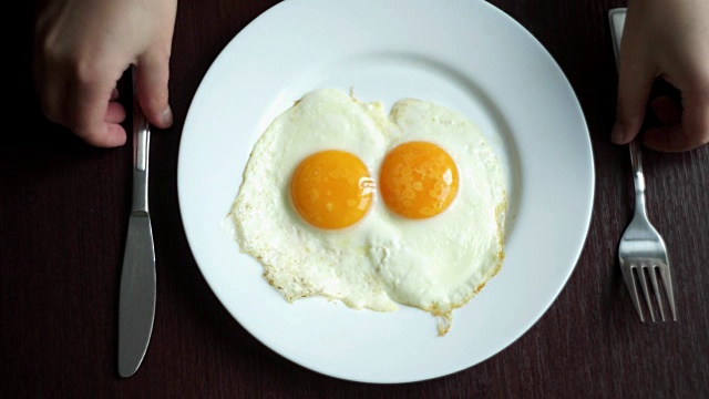 煎蛋吃。俯视图的煎蛋吃与叉和刀视频素材