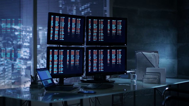 交易员在他的办公桌前开始处理显示在多个显示器上的数字。视频素材