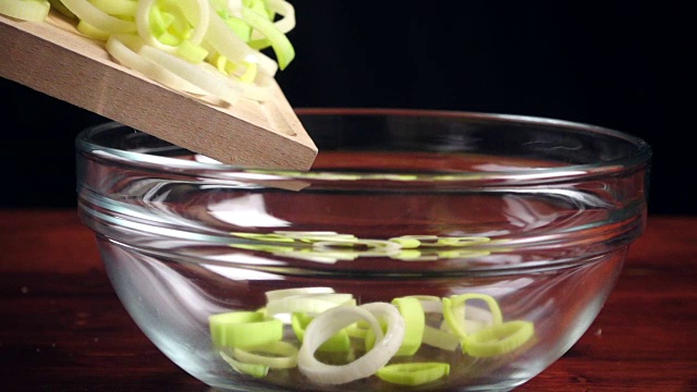 青葱从切菜板上落在玻璃碗上视频素材