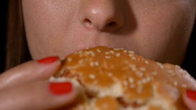 女性嘴的特写吃长咬和吃垃圾不健康的快餐汉堡包视频素材
