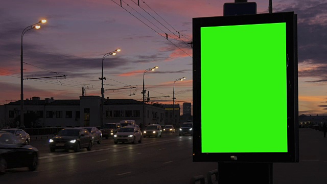 繁忙街道上的一个带有绿色屏风的广告牌。视频素材
