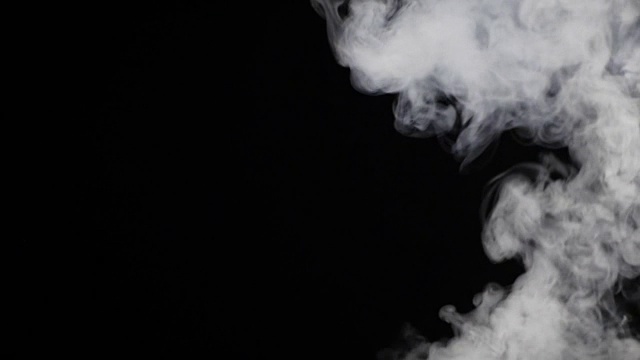 白色的烟雾漂浮在黑色的背景上视频素材