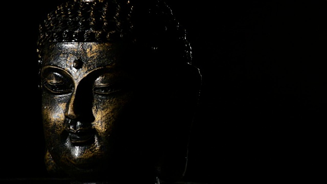 佛面，佛神，旋转于黑色背景左侧正当化视频素材