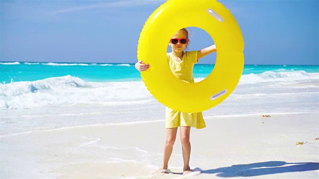 带着充气橡皮圈的小女孩在海滩度假视频下载