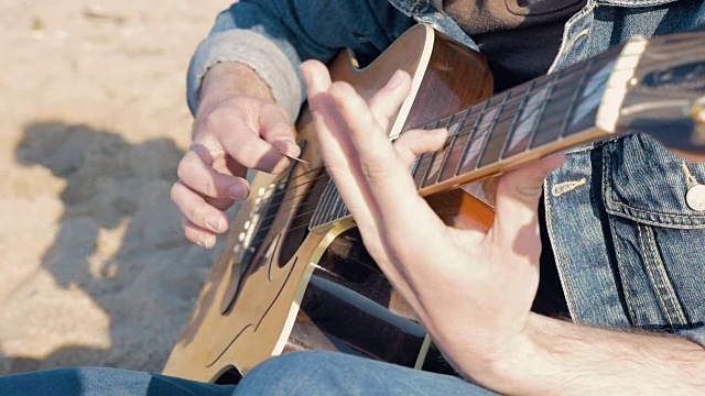 一个男人在沙滩上弹吉他，慢镜头视频下载