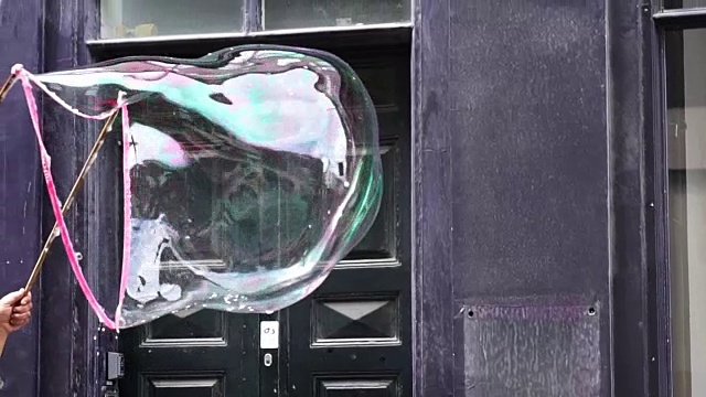 大肥皂泡在空中漂浮，然后以120帧/秒的慢镜头爆炸视频素材