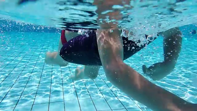 小男孩在游泳池里游泳，水下射击视频下载