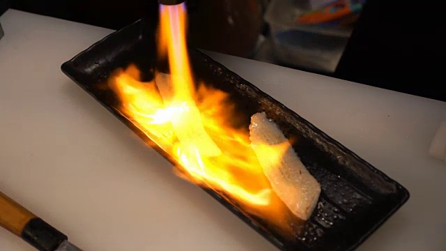 厨师用火把烧了恩加寿司。视频素材
