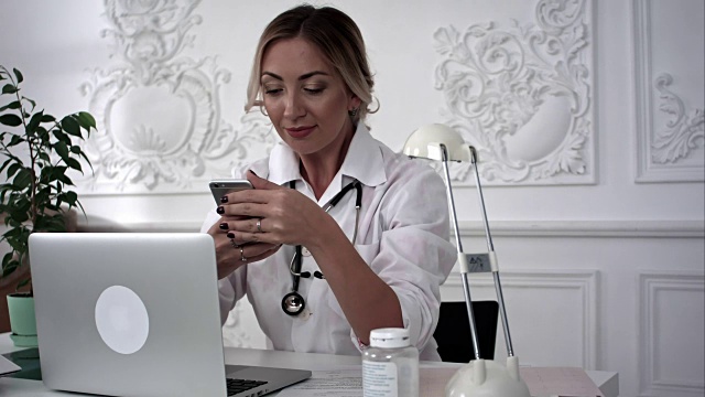 微笑的女医生在用她的智能手机自拍视频素材