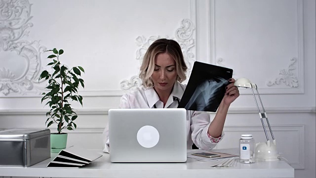 女医生在办公室用笔记本电脑工作。Timelaps视频素材