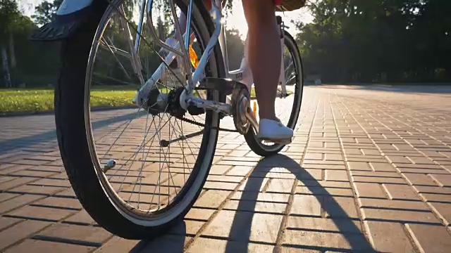 年轻迷人的女孩骑在老式自行车在公园日落，近距离视频素材