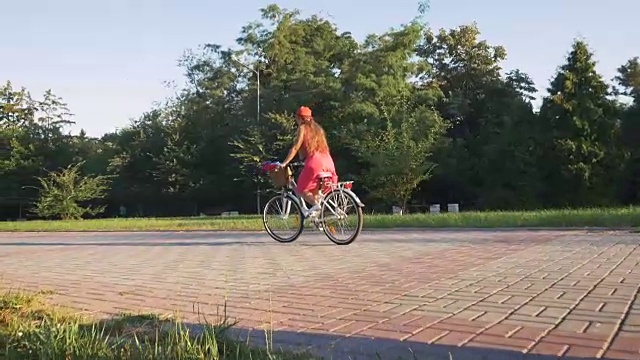 年轻迷人的女孩骑着老式自行车在公园日落视频素材