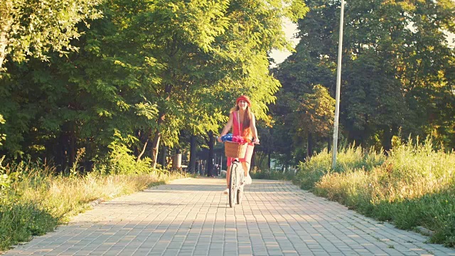 年轻迷人的女孩骑着老式自行车在公园日落视频素材