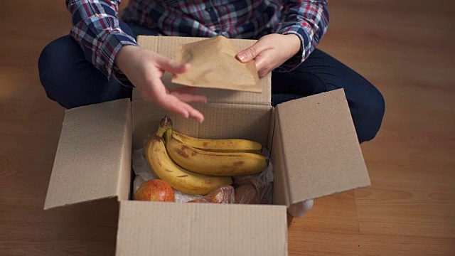 一个女人在家里打开一个食品快递盒视频素材