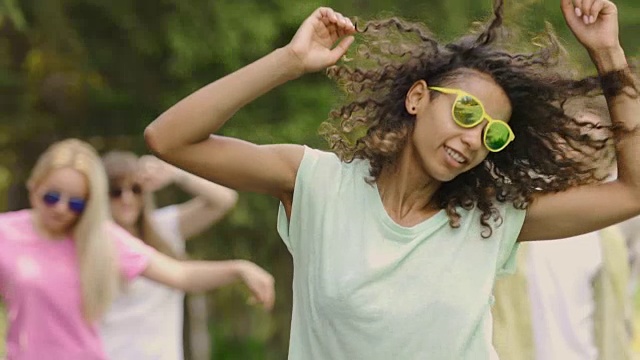 年轻的混血儿女人戴着墨镜在露天才艺表演跳舞，玩得很开心视频下载