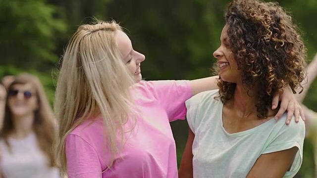 两个美丽的女人拥抱着，在镜头前摆姿势，庆祝生活的年轻人视频下载