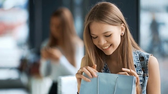 一个漂亮的年轻微笑的女人在超市拿着购物袋视频素材