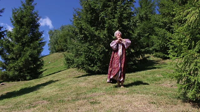 穿着民族服装的女孩在草地上跳舞视频素材