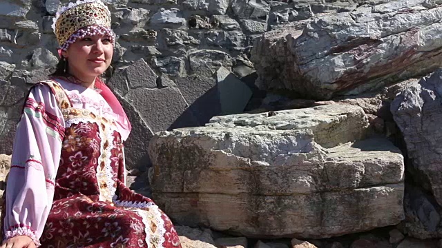 女孩坐在石头上，穿着俄罗斯民间服装视频素材