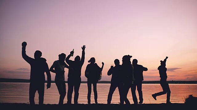 日落时分，一群跳舞的年轻人在海滩上举行聚会视频下载