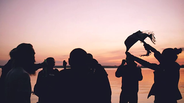 日落时分，一群跳舞的年轻人在海滩上举行聚会视频素材