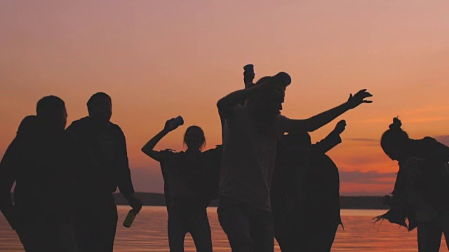 日落时分，一群年轻的舞者在海滩上开派对视频素材