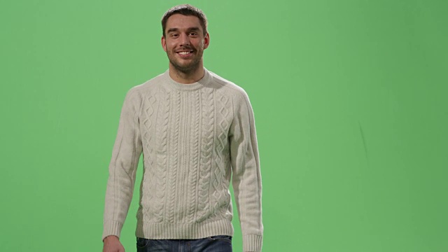 一个随意的白人男人走在一个绿色屏幕模型的背景。视频素材