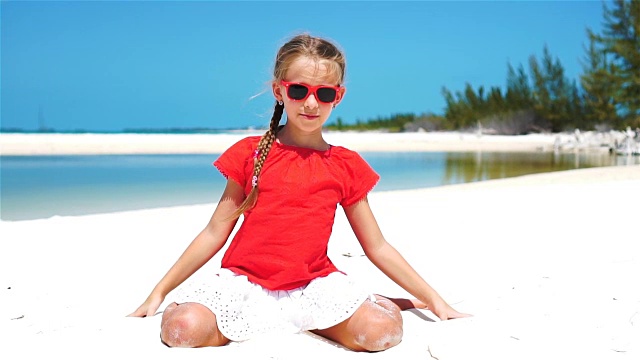 慢镜头特写:女孩玩美丽的白色沙滩在异国情调的海滩视频下载