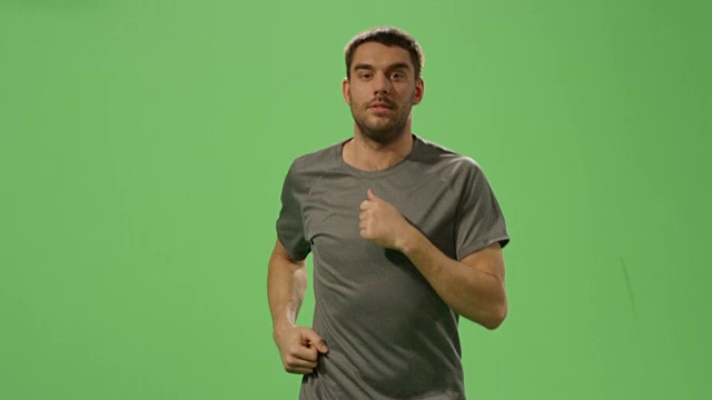 背景是一个绿色屏幕模型，上面是一名身穿t恤的男子在慢跑。视频素材