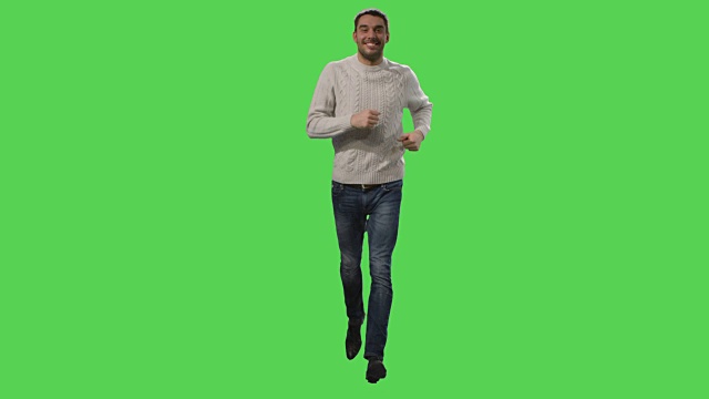 一个穿着外套的休闲男子正在背景的绿色屏幕上奔跑。视频素材