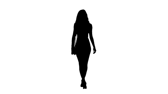 剪影的休闲年轻的黑发女孩在白色的背景下走着裙子。视频下载