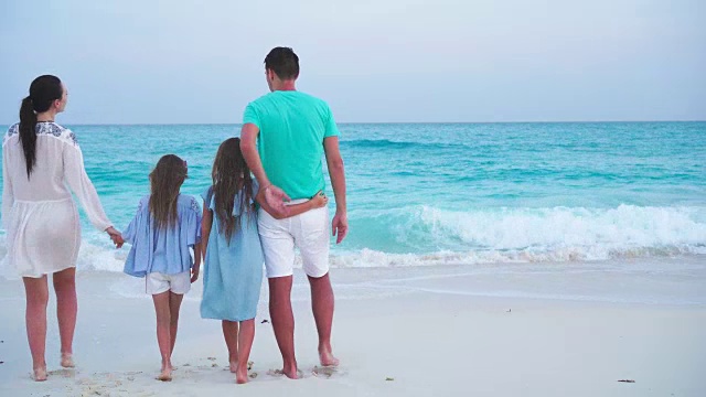 一个年轻的家庭在海滩度假。家庭旅游的概念视频素材