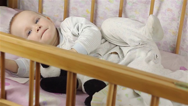 小女孩正躺在床上微笑着拥抱着玩具。视频下载