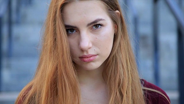 美丽的肖像，愤怒悲伤的年轻女孩与长长的红头发视频下载