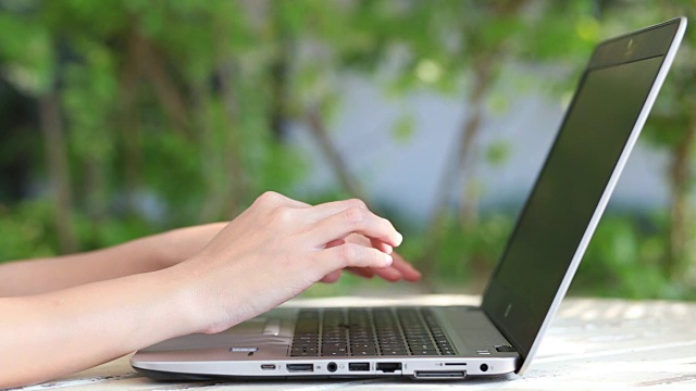 特写商业女人的手打字在笔记本电脑键盘上。视频下载