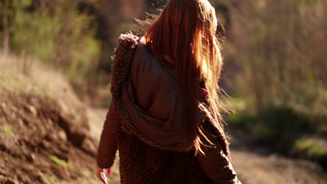 有一头长发的年轻女子走在森林里视频素材