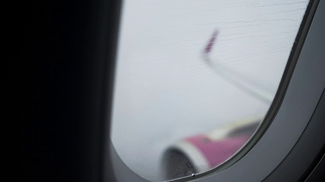 雨打在飞机窗户上，在暴风雨天气下乘坐飞机是危险的视频下载