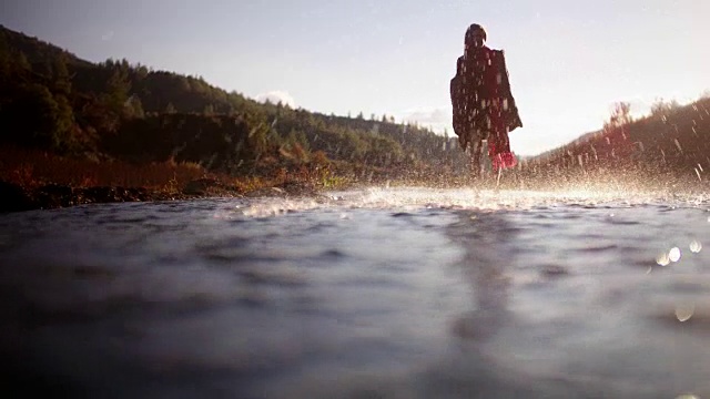 年轻女子赤脚行走，在山河中溅水视频素材