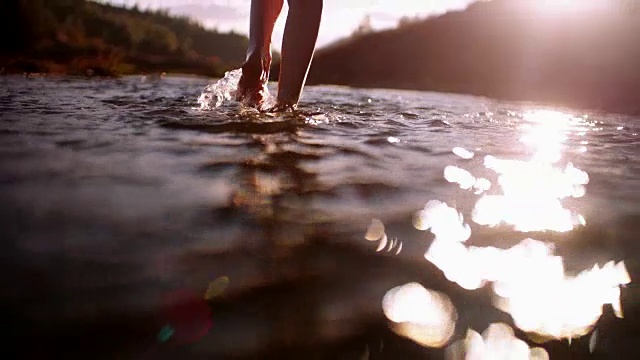 无忧无虑的女人赤脚走在山间的小河里视频素材