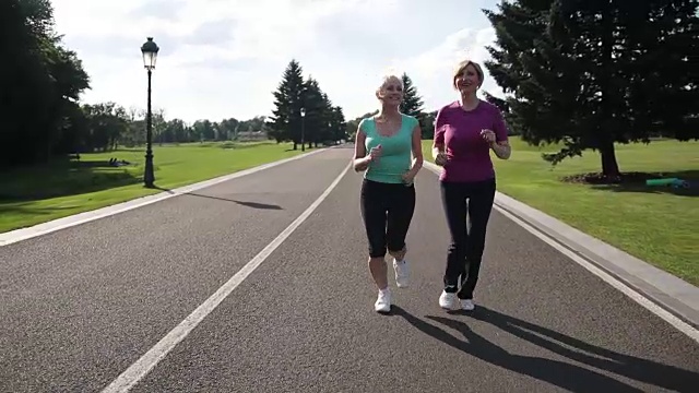 慢跑的老年妇女跑在公园的运动服视频素材