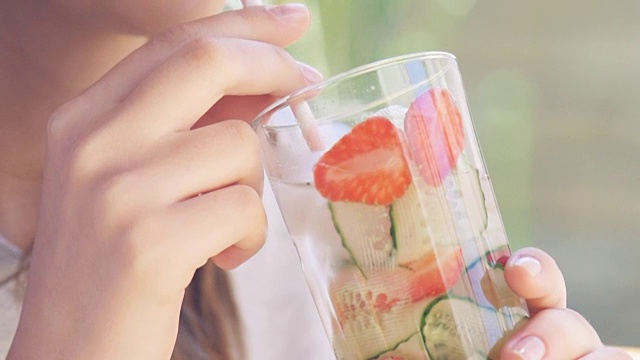 年轻女子喝黄瓜草莓排毒水。视频素材